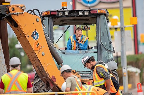 BROOK JONES / FREE PRESS
Daryl Lucking who is an excavator operator with Cambrian Excavators LTD., waits as fellow work crew members inspect the hole he dug at the corner of Pembina Highway and Adamar Road in Winnipeg, Man., Monday, Sept. 16, 2024. Cambrian was doing a land drainage (stormwater sewer) repair.