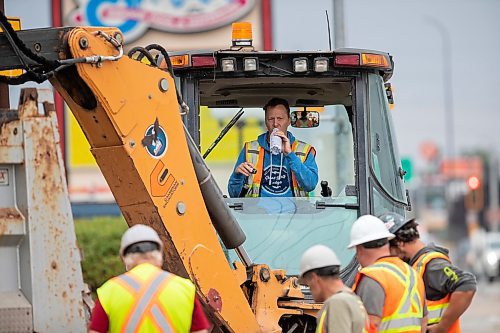 BROOK JONES / FREE PRESS
Daryl Lucking who is an excavator operator with Cambrian Excavators LTD., waits as fellow work crew members inspect the hole he dug at the corner of Pembina Highway and Adamar Road in Winnipeg, Man., Monday, Sept. 16, 2024. Cambrian was doing a land drainage (stormwater sewer) repair.