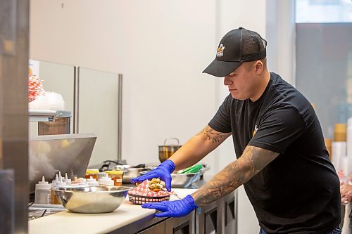 BROOK JONES / FREE PRESS
Thirty-year-old Eric Saniuk who is the owner of Blazing Chicken Shack is pictured preparing a Hot Honey Wafflewich at his restaurant at 392 Graham Ave., in Winnipeg, Man., Monday, Sept. 16, 2024. Saniuk hosted a grand opening Friday, Sept. 13, 2024.