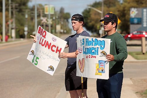 17092024
Aidan McCoy and George Vorster try to lure passersby to a BBQ lunch as part of Boundary Co-op&#x2019;s Fuel Good Day in Boissevain on Tuesday. Proceeds from the BBQ in Boissevain will be going to the Boissevain School Playground Project.
(Tim Smith/The Brandon Sun)