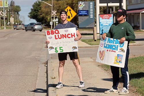 17092024
Aidan McCoy and George Vorster try to lure passersby to a BBQ lunch as part of Boundary Co-op&#x2019;s Fuel Good Day in Boissevain on Tuesday. Proceeds from the BBQ in Boissevain will be going to the Boissevain School Playground Project.
(Tim Smith/The Brandon Sun)