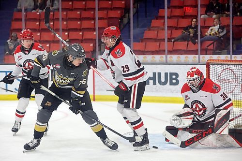 Nicholas Johnson (26) of the Brandon Wheat Kings tries to get the puck around Brayden Yager (29) and past goalie Jackson Unger (30) of the Moose Jaw Warriors during Game 4 of first-round playoff action at Westoba Place in April. All three will have big roles with their clubs this season. (Tim Smith/The Brandon Sun)