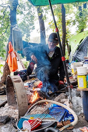 MIKE DEAL / FREE PRESS
Terry trends to a fire while trying to dry off clothing in his campsite at Fort Rouge park Wednesday afternoon.
Reporter: Katrina Clarke
240918 - Wednesday, September 18, 2024.