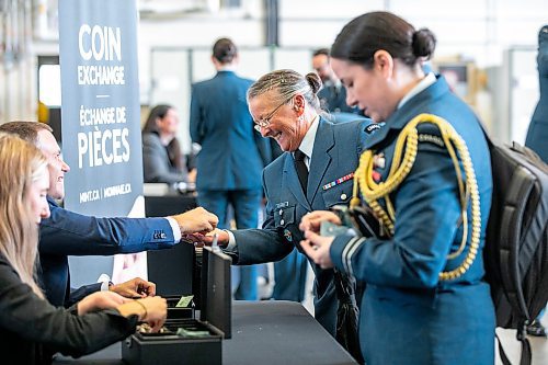 MIKAELA MACKENZIE / WINNIPEG FREE PRESS

Mint employee Matt Traversy hands chief warrant officer Christine McDermid a special two&#x2011;dollar circulation coin commemorating the 100th anniversary of the Royal Canadian Air Force after the unveiling at 17 Wing on Wednesday, Sept. 18, 2024.

Standup.
Winnipeg Free Press 2024