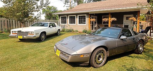 Ray Muirhead's two classic cars, a white 1980 Cadillac Eldorado (left) and a silver 1984 Chevrolet Corvette sitting in the sun in Muirhead's backyard in Carberry. (Photos by Michele McDougall/The Brandon Sun)