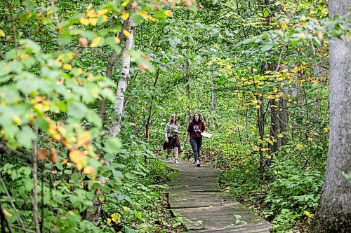 MIKAELA MACKENZIE / WINNIPEG FREE PRESS

Lockport School grade nine students Sam Caslake (left) and Kasey Forman walk the trail at the grand opening of Lord Selkirk School Division&#x573; Albert Beach Trail field trip site on Thursday, Sept. 19, 2024.

For Maggie story.
Winnipeg Free Press 2024