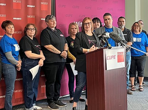 Shannon McAteer, health care co-ordinator for CUPE Manitoba, speaks at a news conference announcing a potential strike date alongside Manitoba Government and General Employees’ Union president Kyle Ross (on McAteer's right) on Tuesday. (Malak Abas/Winnipeg Free Press)