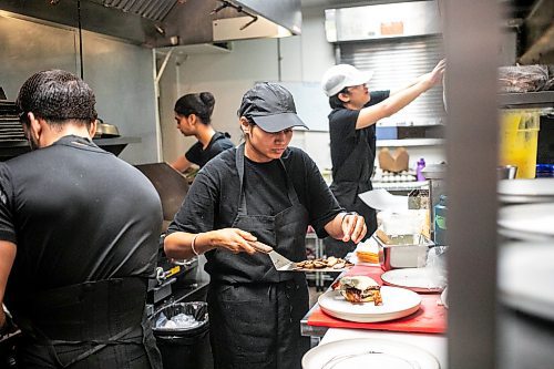 MIKAELA MACKENZIE / WINNIPEG FREE PRESS

Sudha Sharma (centre) whips up orders in the kitchen at the Roasted Nomad on Friday, Sept. 20, 2024. 

For Eva story.
Winnipeg Free Press 2024