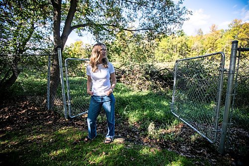 MIKAELA MACKENZIE / WINNIPEG FREE PRESS
	
Cat Macaulay Gauthier with piles of trees that were recently taken down by the developer at Lemay Forest on Sept. 24, 2024. 

For Joyane story.
Winnipeg Free Press 2024