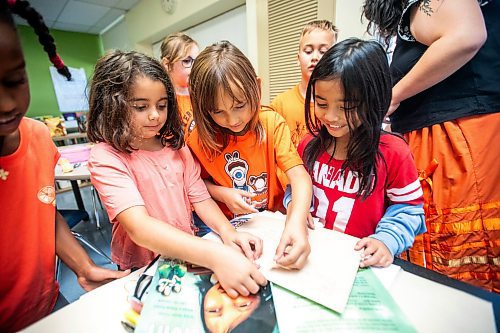 MIKAELA MACKENZIE / WINNIPEG FREE PRESS
	
Grade three/four Victory School students Ivry Hasid (left), Anika Monkman-Sinclair, and Madelyn Cano attach stamps to an envelope of letters addressed to the founder of Orange Shirt Day, Phyllis Webstad, on Wednesday, Sept. 25, 2024. 

For Maggie story.
Winnipeg Free Press 2024