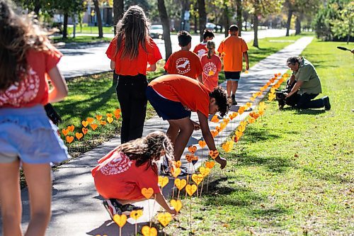 MIKAELA MACKENZIE / FREE PRESS
	
Students place orange hearts along the walkway project at cole Van Walleghem School Thursday, Sept. 26, 2024. 

For Maggie story.
Winnipeg Free Press 2024