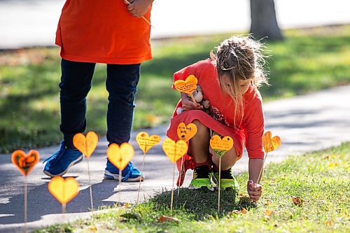 MIKAELA MACKENZIE / FREE PRESS
	
Grade two student Ivy places orange hearts along the walkway project at cole Van Walleghem School Thursday, Sept. 26, 2024. 

For Maggie story.
Winnipeg Free Press 2024