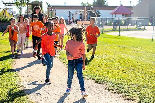 MIKAELA MACKENZIE / WINNIPEG FREE PRESS
	
Grade three/four Victory School students Delina Sium (front left) and Avry Hasid (front right) skip over to drop an envelope of letters to the founder of Orange Shirt Day, Phyllis Webstad, in a Canada Post box on Wednesday, Sept. 25, 2024. 

For Maggie story.
Winnipeg Free Press 2024