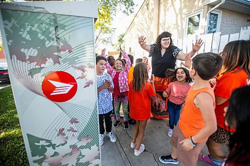 MIKAELA MACKENZIE / WINNIPEG FREE PRESS
	
Reanna Korade, grade three/four teacher at Victory School, celebrates with her class after dropping an envelope of letters to the founder of Orange Shirt Day, Phyllis Webstad, in a Canada Post box on Wednesday, Sept. 25, 2024. 

For Maggie story.
Winnipeg Free Press 2024