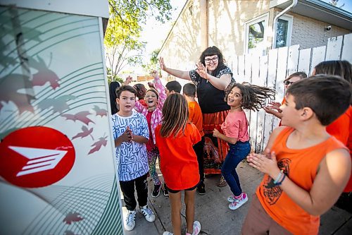 MIKAELA MACKENZIE / WINNIPEG FREE PRESS
	
Reanna Korade, grade three/four teacher at Victory School, celebrates with her class after dropping an envelope of letters to the founder of Orange Shirt Day, Phyllis Webstad, in a Canada Post box on Wednesday, Sept. 25, 2024. 

For Maggie story.
Winnipeg Free Press 2024