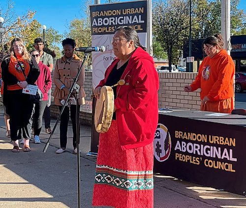 Susie McPherson-Derendy, one of the knowledge keepers at Brandon University and counsellor at the Healing and Wellness Centre, sings a prayer during the raising of the Indigenous flag at Brandon City Hall Friday morning. (Michele McDougall/The Brandon Sun) 