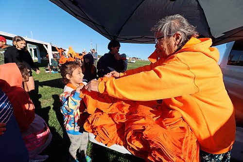 Norma McKay hands out shirts to children during Truth and Reconciliation Day events at the Rolling River First Nation on Friday. (Connor McDowell/Brandon Sun)