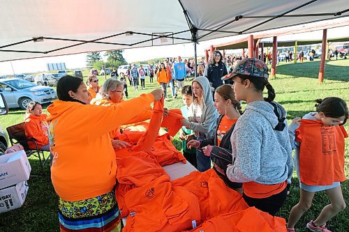 Melanie Cameron (left) and Norma McKay hand out shirts to students at the Rolling River First Nation powwow grounds on Friday for Truth and Reconciliation Day. (Connor McDowell/Brandon Sun)