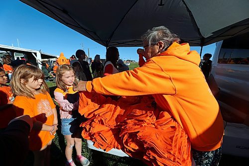 Norma McKay hands out shirts to children during Truth and Reconciliation Day events at the Rolling River First Nation on Friday. (Connor McDowell/Brandon Sun)