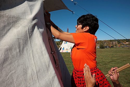 Jennifer Bernhardt with the Brandon Neighbourhood Renewal Corporation’s Ask Auntie program smiles while helping set up a teepee with colleagues during the community teepee raising and teachings at the Riverbank Discovery Centre on the first day of Truth and Reconciliation Week on Friday. (Tim Smith/The Brandon Sun)