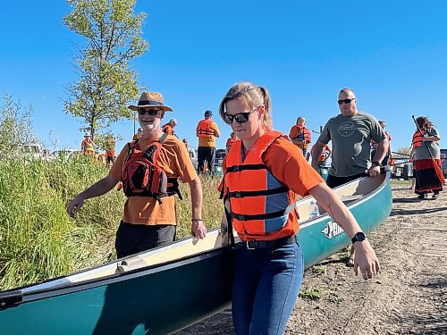 Paddlers carry their canoe to the Assiniboine River, to paddle in the annual Pulling Together event on Saturday, hosted by Brandon Police Service, Brandon Urban Aboriginal Peoples Council and Truth and Reconciliation Week Committee. Sixteen canoes and kayaks made the voyage from Dinsdale Park to the Riverbank Discovery Centre - as part of the numerous activities held to mark the National Day for Truth and Reconciliation. (Michele McDougall/The Brandon Sun)