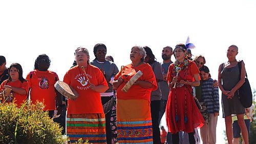 Indigenous singers stand on the bank of the Assiniboine River at the Riverbank Discovery Centre on Saturday as they welcome canoeists who paddled from Dinsdale Park. The annual Pulling together event was hosted by Brandon Police Service, Brandon Urban Aboriginal Peoples Council and Truth and Reconciliation Week Committee. The sixteen canoes and kayaks were part of the numerous activities held to mark the National Day for Truth and Reconciliation. (Michele McDougall/The Brandon Sun)