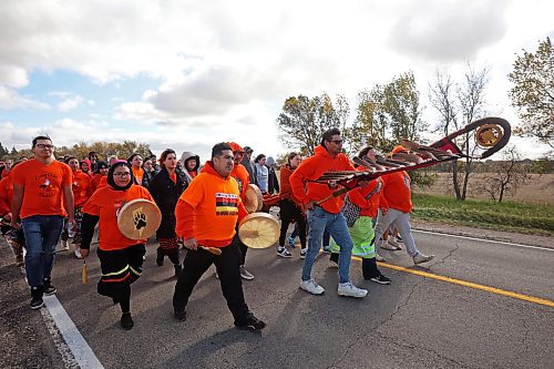 Frederick Wood carries the Brandon Friendship Centre Eagle Staff while leading participants to the former Brandon Residential School site during the Truth and Reconciliation Week 2024 Orange Shirt Day Walk on Monday. (Tim Smith/The Brandon Sun)