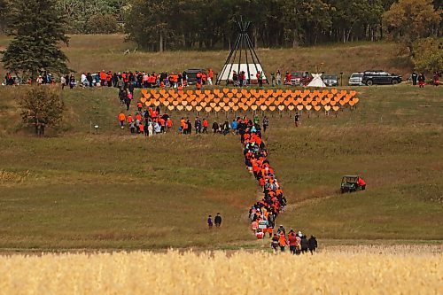 30092024
Participants make their way from Grand Valley Road across a field to the former Brandon Residential School site during the Truth and Reconciliation Week 2024 Orange Shirt Day Walk on Monday. The walk began and ended at the Riverbank Discovery Centre grounds with speeches, teaching and ceremony at the former Brandon Residential School site. Orange hearts line the hill at the site in memory of children who died while attending the Residential School.  (Tim Smith/The Brandon Sun)