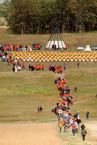 30092024
Participants make their way from Grand Valley Road across a field to the former Brandon Residential School site during the Truth and Reconciliation Week 2024 Orange Shirt Day Walk on Monday. The walk began and ended at the Riverbank Discovery Centre grounds with speeches, teaching and ceremony at the former Brandon Residential School site. Orange hearts line the hill at the site in memory of children who died while attending the Residential School.  (Tim Smith/The Brandon Sun)