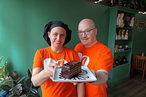 Angie and James Chambers of Chez Angela Bakery and Café show their gluten-free 10-layer chocolate cake on Tuesday. The cake is Chez Angela’s fair-trade creation for Fair Trade Treat Month. Lady of the Lake and The Dock on Princess also are participating in the initiative. (Tim Smith/The Brandon Sun)