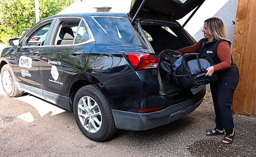 Niki Harper with Vision Loss Rehabilitation Canada, a sister organization to CNIB, loads a tote bag into the back of a 2024 black Chevrolet Equinox that was purchased by the Wheat City Lions Club and donated to the two non-profits. (Michele McDougall/The Brandon Sun) 