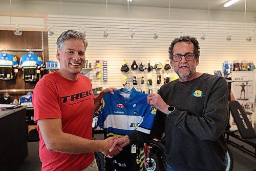 A&L Cycle co-owner Cam Wirch shakes hand and present jersey to cyclist Grant Hamilton after the announcement on Wednesday afternoon at the A&L Cycle office located at 201 Rosser Ave. (Abiola Odutola/The Brandon Sun)