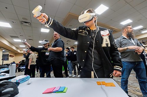 MIKE DEAL / FREE PRESS
Shelby Brown, 16, grade 11 student at Crocus Plains Regional Secondary School in Brandon, MB, tries out a virtual training tool running a program, Sprayverse, that helps teach the process of industrial painting, during a demonstration at the Automotive Trades Association (ATA) second annual High School Career Day being held at CanadInns Polo Park on Friday.
Reporter: Aaron Epp
241004 - Friday, October 04, 2024.