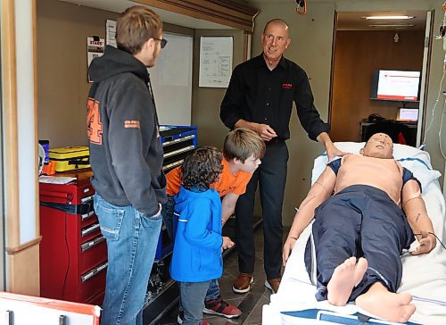 Brent Bekiaris, flight paramedic for STARS and the education lead for the air ambulance's mobile unit, shows the training mannequin to the Steed family during Thursday's fundraiser. (Michele McDougall/The Brandon Sun)