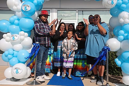 Birdtail Sioux First Nation Chief Lindsay Bunn Jr., Dakota Urban case manager for Canupawakpa and former Sioux Valley Dakota Nation chief Jennifer Bone and Canupawakpa Dakota Nation Chief Raymond Brown surround seven-year-old Fawn Kasto of Birdtail Sioux First Nation, who lives in Brandon, along with other dignitaries as she cuts the ribbon during the grand opening of the Dakota Urban Jordan’s Principle office on Richmond Avenue in Brandon on Friday. (Tim Smith/The Brandon Sun)