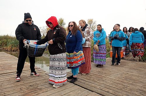 Participants line up to receive petals and tobacco during the petal ceremony. (Tim Smith/The Brandon Sun)