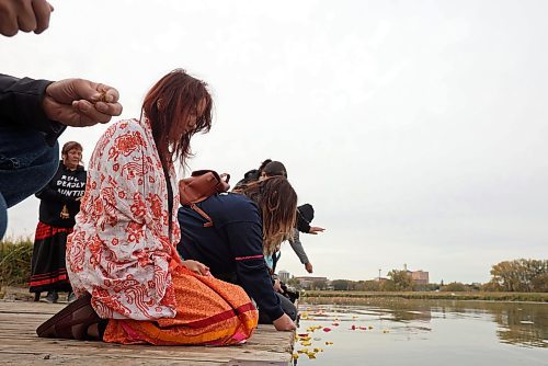 04102024
Participants place flower petals and tobacco in the Assiniboine River in honour and remembrance of missing and murdered indigenous women and girls during the Sisters In Spirit petal ceremony at Dinsdale Park on Friday morning.  
(Tim Smith/The Brandon Sun)