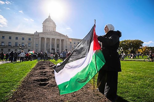 Mike Sudoma/Free Press
Protester Manar Elmekkawy sticks a Palestinian flag in the ground during a pro Palestinian rally at the Manitoba Legislative Grounds Saturday afternoon 
October 5, 2024
