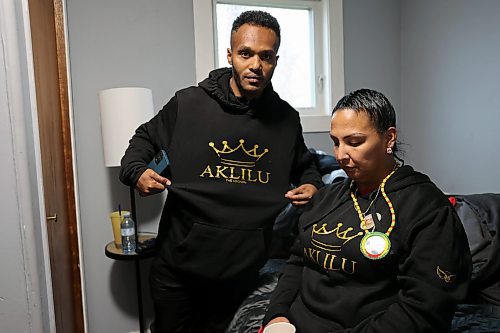 Alazar Asrat and Nicole Sutherland, father and mother of Antoine, are in the back room of a gathering held for the memorial of their late son. They share their stories of grief on the one-year mark since their son was struck by a vehicle and killed. Their hoodies bear his middle name, Aklilu, passed on from the father's side of the family. (Connor McDowell/Brandon Sun)