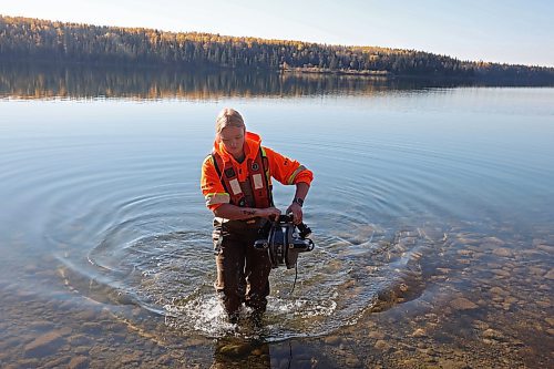 Caitlyn Stevenson, a resource management technician with Parks Canada, carefully carries an underwater remote operated vehicle out of Clear Lake while inspecting a water-intake area used for the Clear Lake Golf Course with colleagues at Riding Mountain National Park on Wednesday. The technicians were conducting a general inspection as well as looking for evidence of zebra mussels and training some of technicians on operation of the ROV. The ROV is on loan to the park from the Parks Canada archeology branch. (Tim Smith/The Brandon Sun)