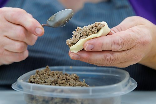 MIKE DEAL / FREE PRESS
Deb takes little balls of dough and adds the filing.
Deb Rogalsky, founder of Deb's Meat Buns, runs her home-based enterprise out of a commercial kitchen attached to her home in Landmark, Manitoba. 
She bakes as many as 300 dozen meat buns a week.
She turns out over a dozen varieties of meat buns, or perishky, including pulled pork, buffalo chicken and taco - as well as one called the Original (ground beef, onions, mashed potatoes) based on a recipe developed by Deb's mom, decades ago. 
Reporter: Dave Sanderson
241009 - Wednesday, October 09, 2024.