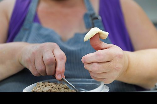 MIKE DEAL / FREE PRESS
Deb takes little balls of dough and adds the filing.
Deb Rogalsky, founder of Deb's Meat Buns, runs her home-based enterprise out of a commercial kitchen attached to her home in Landmark, Manitoba. 
She bakes as many as 300 dozen meat buns a week.
She turns out over a dozen varieties of meat buns, or perishky, including pulled pork, buffalo chicken and taco - as well as one called the Original (ground beef, onions, mashed potatoes) based on a recipe developed by Deb's mom, decades ago. 
Reporter: Dave Sanderson
241009 - Wednesday, October 09, 2024.