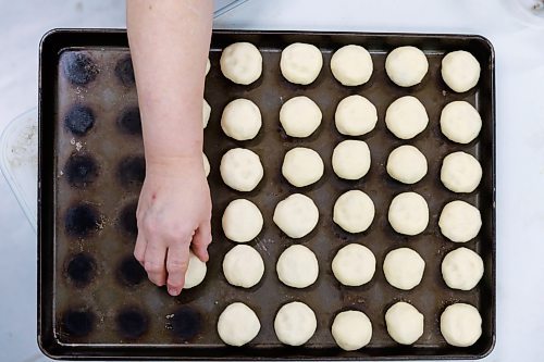 MIKE DEAL / FREE PRESS
Deb takes little balls of dough and adds the filing.
Deb Rogalsky, founder of Deb's Meat Buns, runs her home-based enterprise out of a commercial kitchen attached to her home in Landmark, Manitoba. 
She bakes as many as 300 dozen meat buns a week.
She turns out over a dozen varieties of meat buns, or perishky, including pulled pork, buffalo chicken and taco - as well as one called the Original (ground beef, onions, mashed potatoes) based on a recipe developed by Deb's mom, decades ago. 
Reporter: Dave Sanderson
241009 - Wednesday, October 09, 2024.