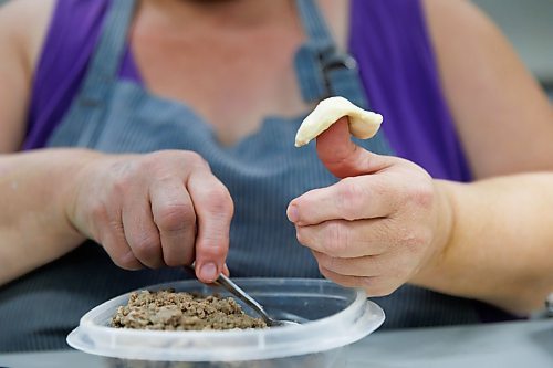 MIKE DEAL / FREE PRESS
Deb takes little balls of dough and adds the filing.
Deb Rogalsky, founder of Deb's Meat Buns, runs her home-based enterprise out of a commercial kitchen attached to her home in Landmark, Manitoba. 
She bakes as many as 300 dozen meat buns a week.
She turns out over a dozen varieties of meat buns, or perishky, including pulled pork, buffalo chicken and taco - as well as one called the Original (ground beef, onions, mashed potatoes) based on a recipe developed by Deb's mom, decades ago. 
Reporter: Dave Sanderson
241009 - Wednesday, October 09, 2024.