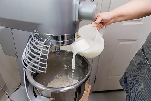 MIKE DEAL / FREE PRESS
Making the dough, Deb adds milk to the mixer.
Deb Rogalsky, founder of Deb's Meat Buns, runs her home-based enterprise out of a commercial kitchen attached to her home in Landmark, Manitoba. 
She bakes as many as 300 dozen meat buns a week.
She turns out over a dozen varieties of meat buns, or perishky, including pulled pork, buffalo chicken and taco - as well as one called the Original (ground beef, onions, mashed potatoes) based on a recipe developed by Deb's mom, decades ago. 
Reporter: Dave Sanderson
241009 - Wednesday, October 09, 2024.