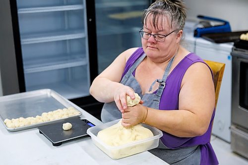 MIKE DEAL / FREE PRESS
Deb fills a tray with little balls of dough that she weighs individually. As he children grew up, they often dreamed of this part of the process being automated.
Deb Rogalsky, founder of Deb's Meat Buns, runs her home-based enterprise out of a commercial kitchen attached to her home in Landmark, Manitoba. 
She bakes as many as 300 dozen meat buns a week.
She turns out over a dozen varieties of meat buns, or perishky, including pulled pork, buffalo chicken and taco - as well as one called the Original (ground beef, onions, mashed potatoes) based on a recipe developed by Deb's mom, decades ago. 
Reporter: Dave Sanderson
241009 - Wednesday, October 09, 2024.