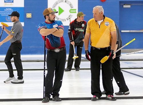 Seth White, left, and Rob Van Kommer of Team Ed Barr discuss a shot during the opening night draw. (Thomas Friesen/The Brandon Sun)