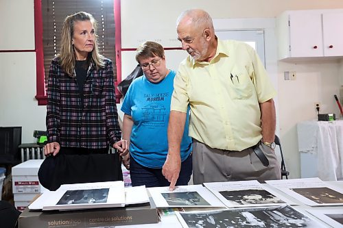 Frank Cedar goes over photos of Brandon’s Polish community with Lori-Lynn Sanduliak (left), whose relatives are featured, and Eileen Trott, curator of the Daly House Museum, on Thursday. (Tim Smith/The Brandon Sun)