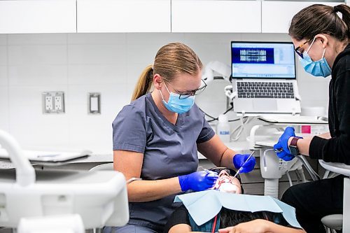 MIKAELA MACKENZIE / FREE PRESS
	
Dentist Carolyn Roberston (left) and dental assistant Kaylen Wallbridge demonstrate their craft on administrator Mameet Kaur at Harte Dental on Thursday, Oct. 10, 2024.

For AV story.
Winnipeg Free Press 2024