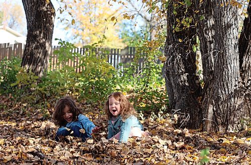 Brother and sister four-year-old Levi (left) and two-year-old Rowa play in the leaves on Thanksgiving Day near a walking path in Brandon's west end. (Michele McDougall/The Brandon Sun)